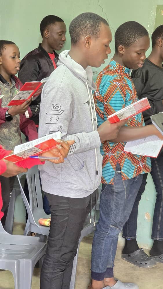 Children standing together with colourful activity materials at 5 Day Club