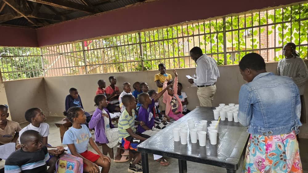 Children and leaders gathered around tables in a covered outdoor area at 5 Day Club