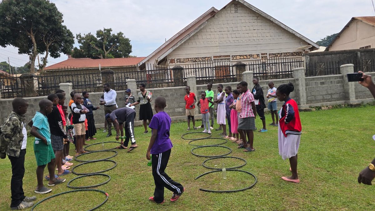 Children lining up beside hoops for games on the church lawn at 5 Day Club