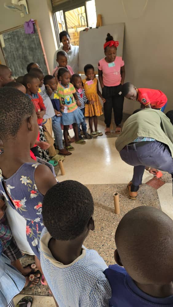 Children watching their leaders during an indoor activity at 5 Day Club