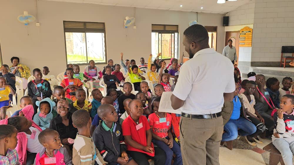 A leader speaking with children seated together at 5 Day Club