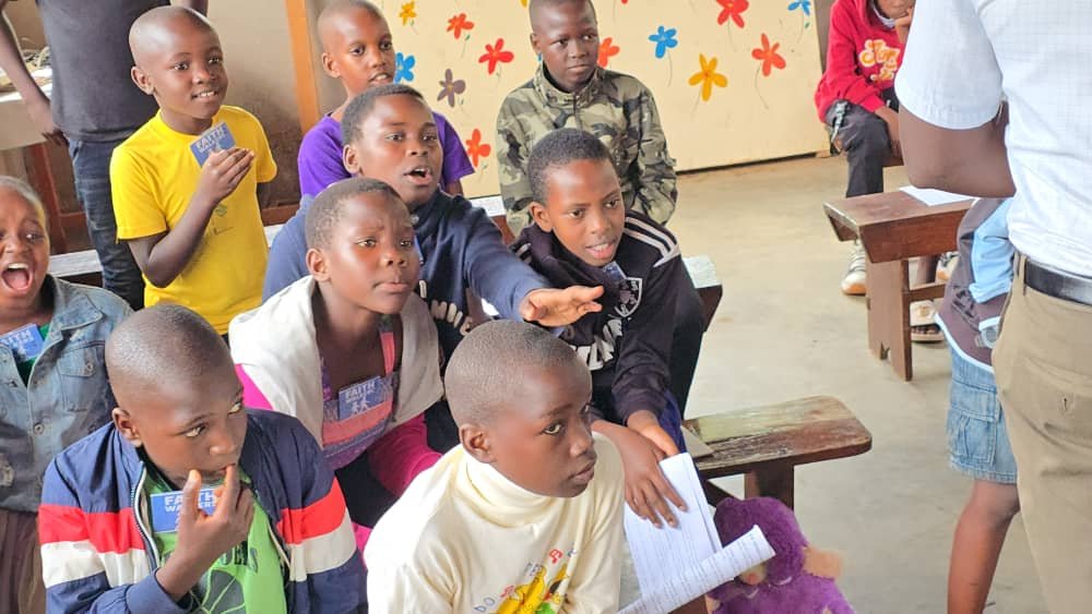 Children taking part in a group activity with a leader at 5 Day Club