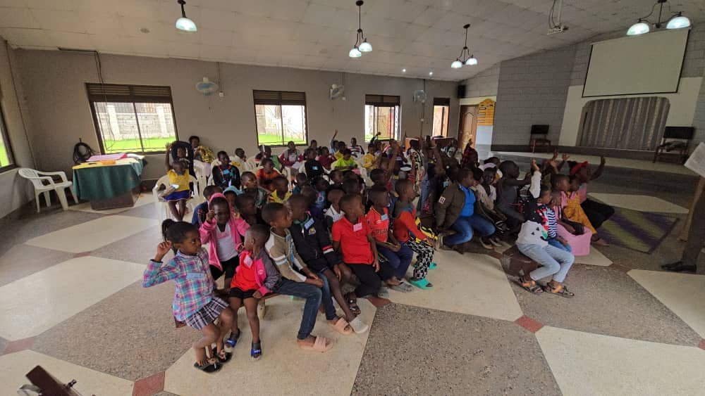 Children seated together with their leaders in the church sanctuary at 5 Day Club