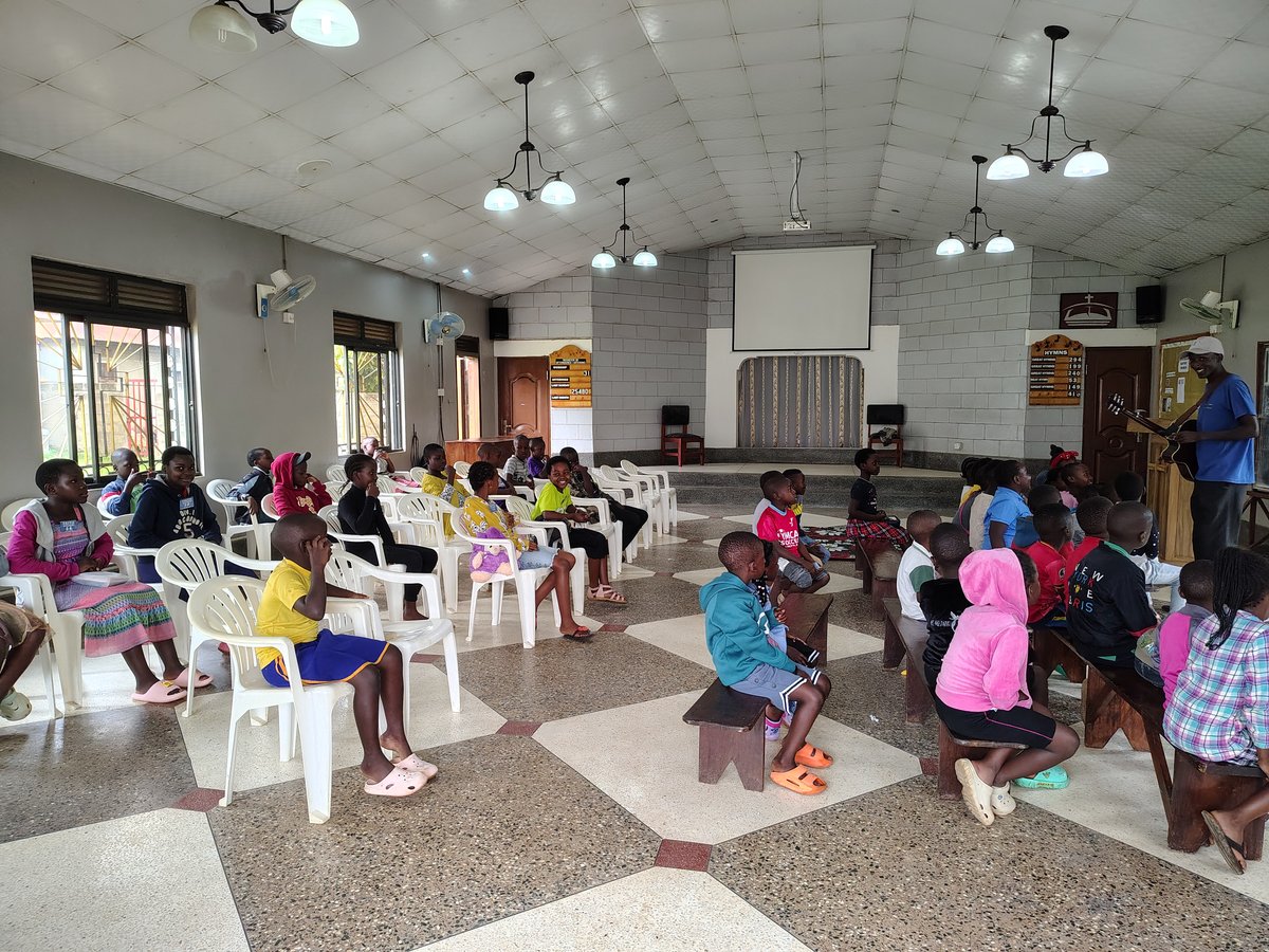 Children gathered among the chairs inside the church at 5 Day Club