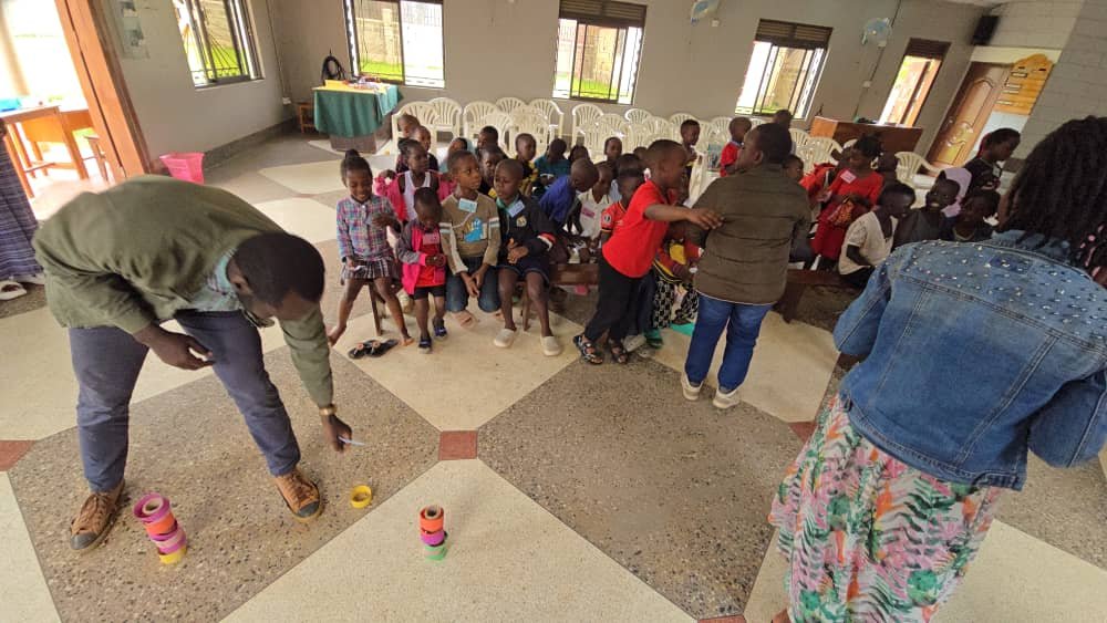 Children watching an indoor game with their leaders at 5 Day Club
