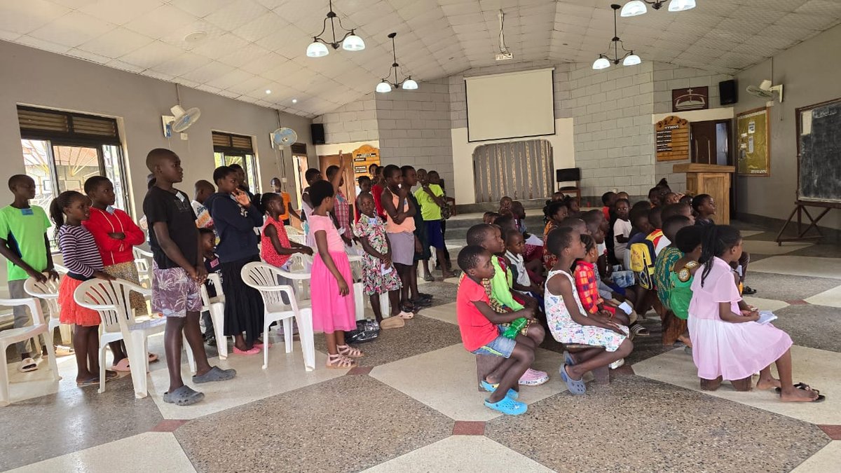 Children and leaders sitting and standing in the sanctuary at 5 Day Club
