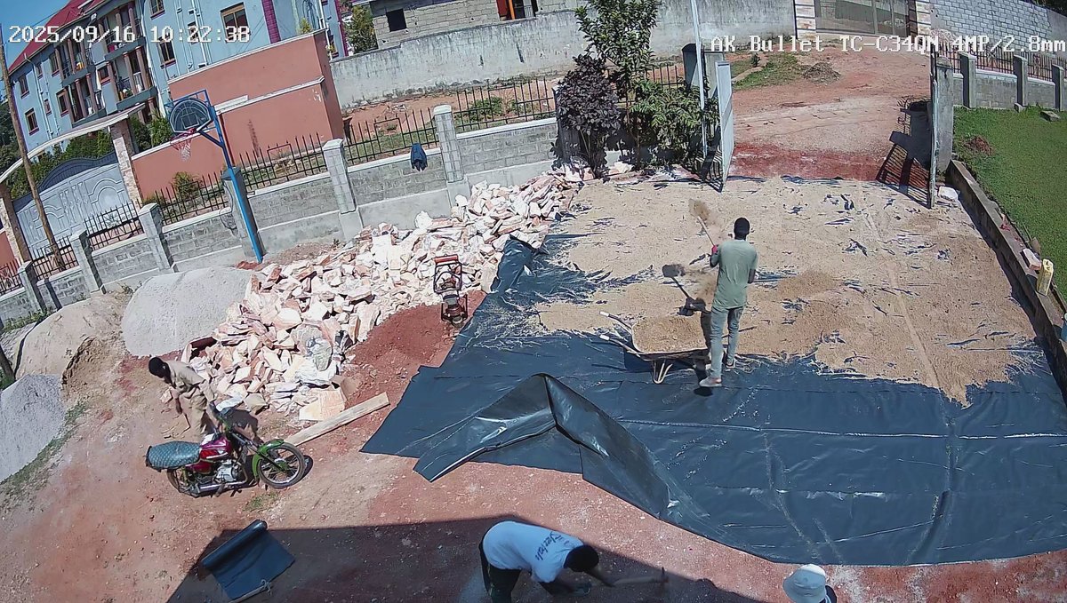 Workers preparing a covered base for paving inside the church grounds