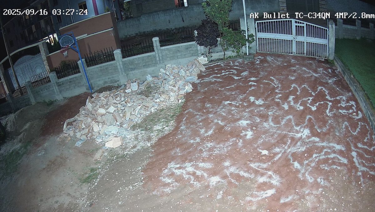 The church grounds prepared for paving, with stones piled beside the boundary wall