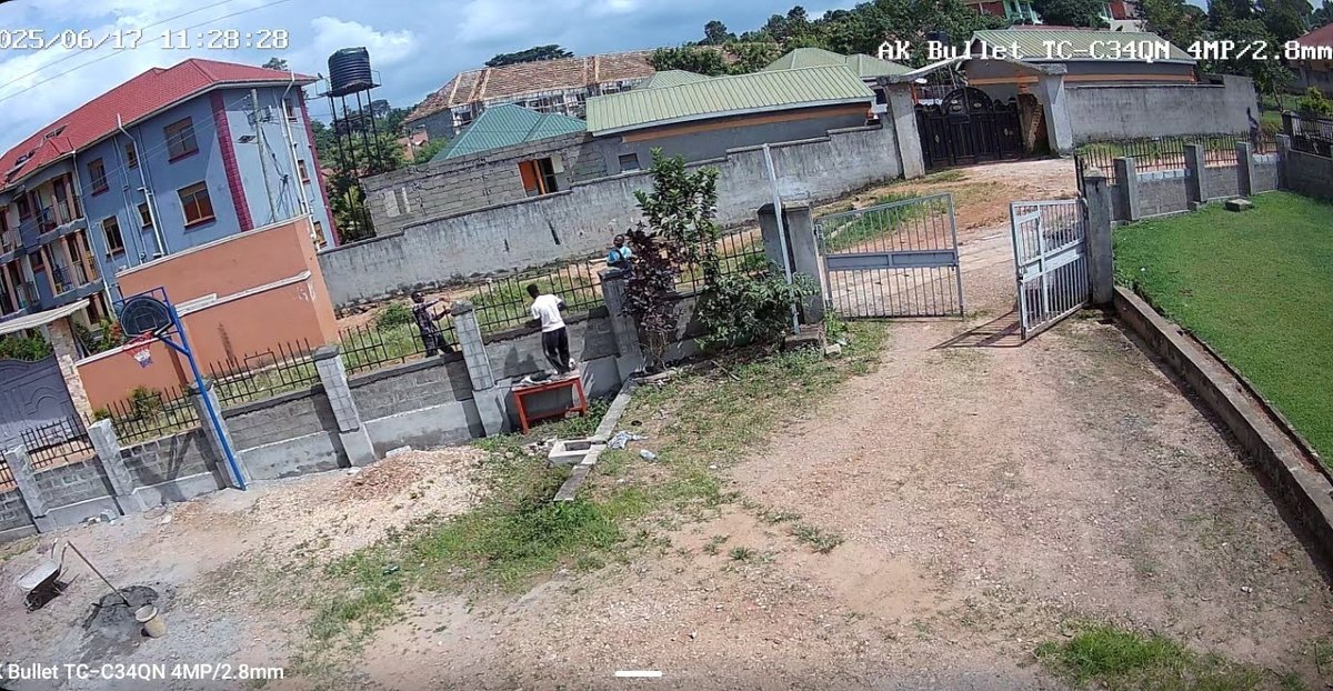 People working along the church boundary wall beside the entrance gate